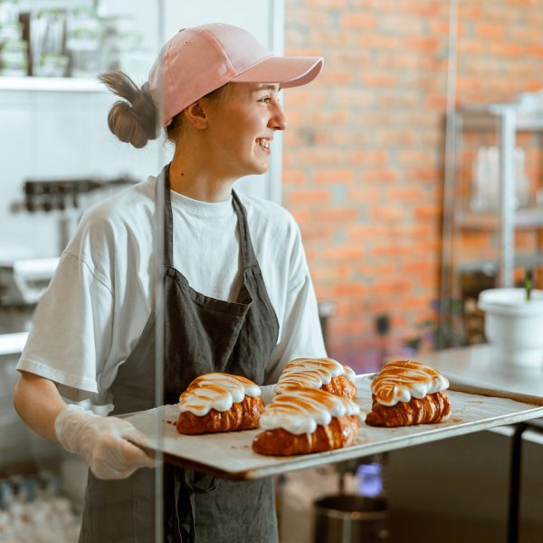 pretty-woman-baker-holds-beautiful-croissants-with-burnt-albumenous-cream-in-shop.jpg